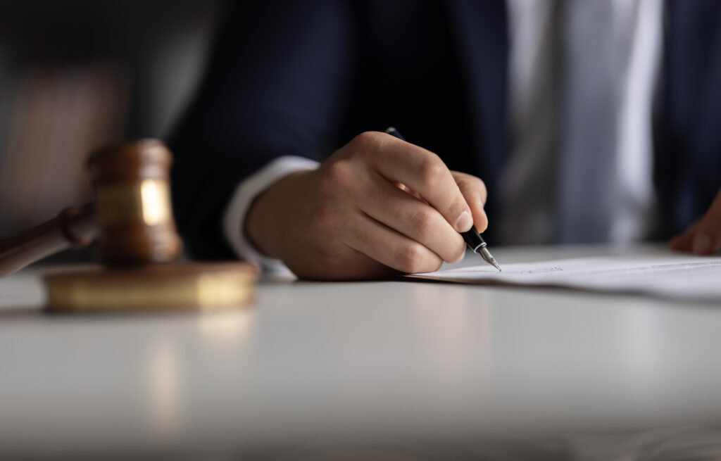 Judge or Legal advisor lawyer examining and signing legal documents for Domestic Violence Charges.